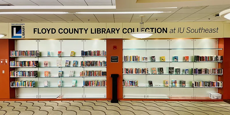 Bookshelves in IU Southeast library with the words Floyd County Library Section above